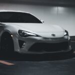 Luxury Cars - Stylish white sports car parked in a dimly lit u #17245039