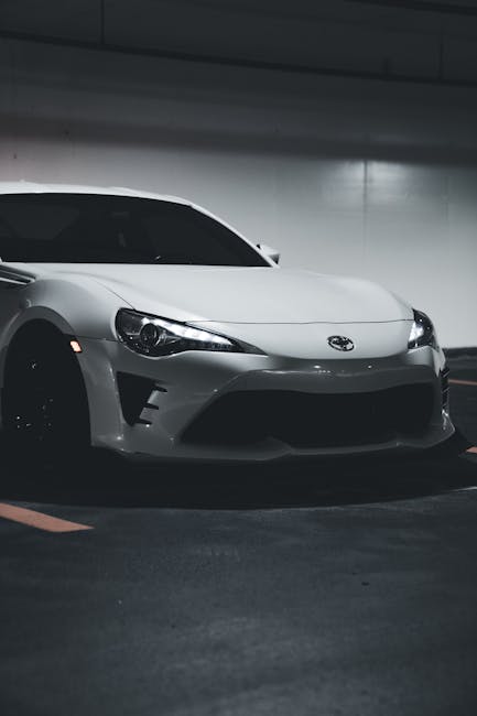 Luxury Cars - Stylish white sports car parked in a dimly lit u #17245039