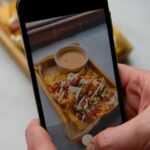 Food Aesthetics - Hand holding smartphone capturing a photo of nac #20270642