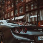 Luxury Cars - Sleek black sports car parked in a vibrant urban #20296990