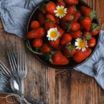 Food Aesthetics - A bowl of fresh strawberries with daisies on a r #23913653
