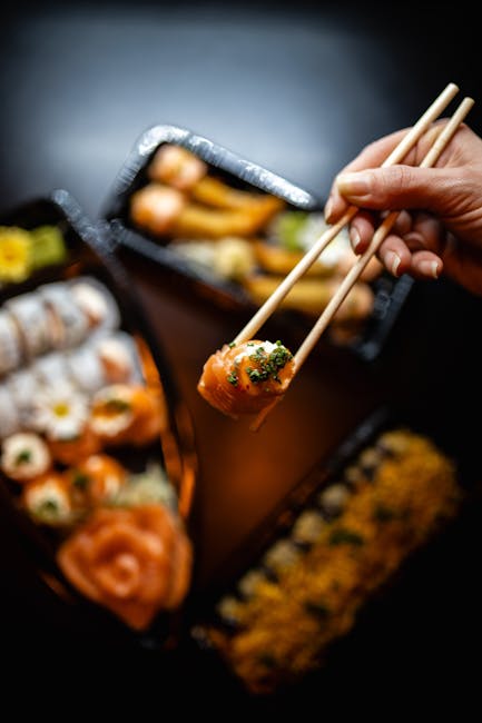 Food Aesthetics - Close-up of a hand holding sushi with chopsticks #30222105