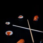 Food Aesthetics - Assorted sushi pieces and chopsticks on a black #31286807